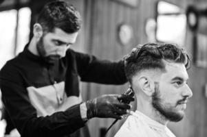 bel homme barbu au salon de coiffure, coiffeur au travail. photo