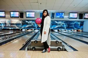 élégante femme asiatique debout au bowling avec ballon à portée de main. photo