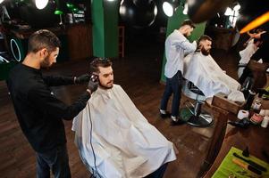 bel homme barbu au salon de coiffure, coiffeur au travail. photo