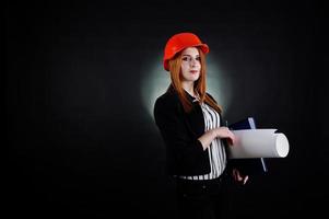 ingénieur femme en orange protéger casque avec projet de papier de construction. photo