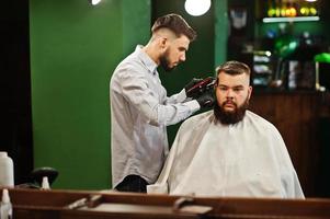 bel homme barbu au salon de coiffure, coiffeur au travail. photo