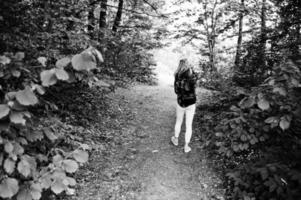 portrait d'une belle jeune femme blonde en chemise tartan tenant une carte dans la forêt. photo