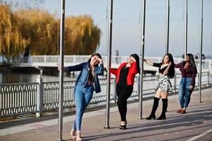 groupe de quatre filles latinos heureuses et jolies de l'équateur posées dans la rue. photo