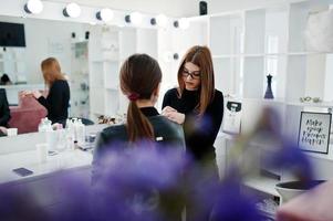 maquilleuse travaille dans son salon de studio de beauté. femme postulant par un maître de maquillage professionnel. concept de club de beauté. photo