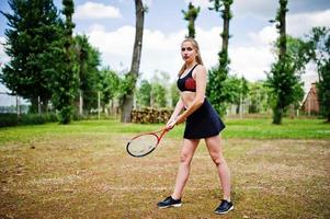 belle joueuse de tennis sportive avec raquette en costume de sport. photo