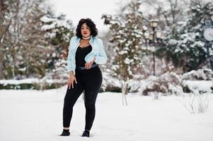 élégant modèle de taille plus afro-américain avec téléphone portable à portée de main le jour de neige d'hiver. photo