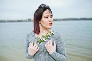 portrait de jeune fille brune en robe grise fond le lac. photo