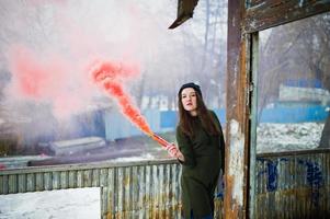 jeune fille avec une bombe fumigène de couleur rouge à la main. photo