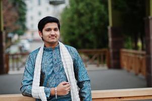 l'homme indien porte des vêtements traditionnels avec une écharpe blanche posée à l'extérieur. photo