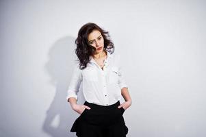 portrait en studio de jeune fille brune en blouse blanche sur fond blanc. photo