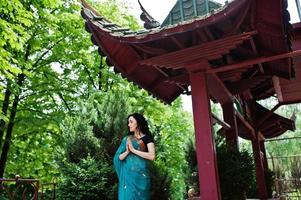 portrait d'une belle fille de brumette indienne ou d'un modèle de femme hindoue contre une maison traditionnelle japonaise. photo