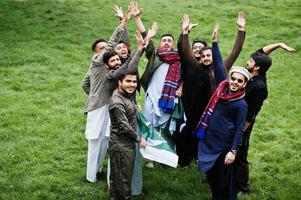 groupe d'hommes pakistanais portant des vêtements traditionnels salwar kameez ou kurta avec des drapeaux pakistanais. photo