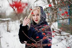 fille blonde avec écharpe brodée à la main posée au jour d'hiver. mouchoir femme. photo