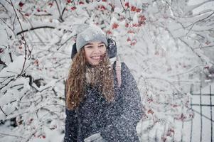 portrait de jeune fille au jour de neige d'hiver près des arbres couverts de neige. photo