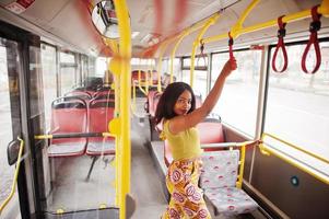 jeune femme afro-américaine élégante à cheval dans un bus. photo