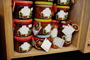 bocaux en verre avec différents types de confiture et de baies d'un supermarché ou d'une épicerie. produits de conserve maison. fait avec amour. photo