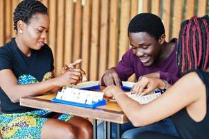 groupe de trois amis afro-américains jouent à des jeux de table. photo