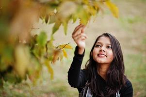 portrait de jeune belle adolescente indienne ou sud-asiatique en robe posée au parc d'automne. photo