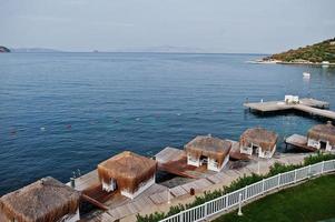 jetée en bois avec cabanas. paysage pittoresque avec îles de montagne et lagon bleu sur la mer Égée. paysage exotique. point de repère populaire, célèbre destination de bodrum, turquie. photo