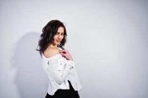 portrait en studio de jeune fille brune en blouse blanche sur fond blanc. photo