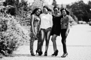 groupe de quatre filles afro-américaines posées en plein air de bonne humeur. photo