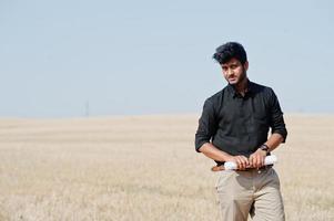 Agriculteur agronome sud-asiatique inspectant une ferme de champs de blé. notion de production agricole. photo