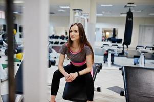 jeune fille mince sexy brune faisant de l'exercice au gymnase. photo