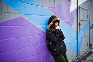 jeune fille posée contre un mur coloré par temps froid. photo