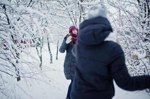 deux amis drôles de filles s'amusant à la journée enneigée d'hiver près des arbres couverts de neige. photo