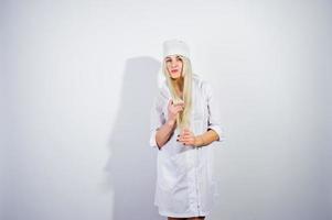 jolie blonde femme médecin ou infirmière en blouse de laboratoire isolée sur fond blanc. photo