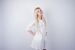 jolie blonde femme médecin ou infirmière en blouse de laboratoire isolée sur fond blanc. photo