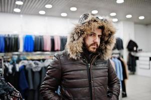 homme turc élégant au magasin de manteaux de fourrure et de vestes en cuir. homme barbe arabe réussi. photo