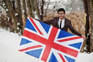 homme indien élégant en costume avec le drapeau de la grande-bretagne posé à la journée d'hiver en plein air. photo