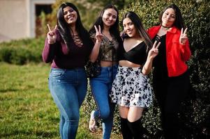 groupe de quatre filles latinos heureuses et jolies de l'équateur posées dans la rue. photo