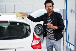 homme sud-asiatique ou homme indien lavant son transport blanc sur le lave-auto. photo