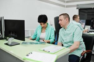 thème médical.deux médecins se réunissant dans le bureau de l'irm au centre de diagnostic de l'hôpital, assis près des moniteurs d'ordinateur. photo