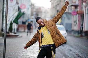 un homme africain porte une veste par temps froid posé à l'extérieur. photo