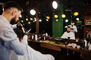 bel homme barbu au salon de coiffure, coiffeur au travail. photo