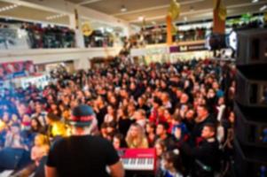 photo estompée salle de concert bondée avec des lumières de scène avec des gens à la performance rock.