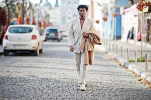 homme afro élégant en costume beige old school. jeune homme africain à la mode en veste décontractée sur torse nu. photo