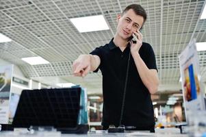 vendeur homme consultant professionnel en téléphonie mobile dans un magasin de technologie ou un magasin. photo