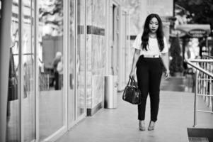 élégante femme d'affaires afro-américaine avec sac à main dans les rues de la ville. photo