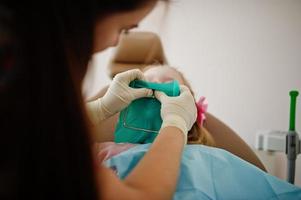 petite fille au fauteuil de dentiste. enfants dentaires. photo