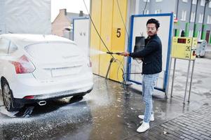 homme sud-asiatique ou homme indien lavant son transport blanc sur le lave-auto. photo