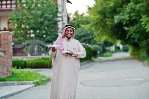 homme d'affaires arabe du moyen-orient posé dans la rue avec un drone ou un quadricoptère à portée de main. photo