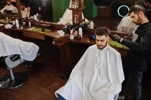 bel homme barbu au salon de coiffure, coiffeur au travail. photo