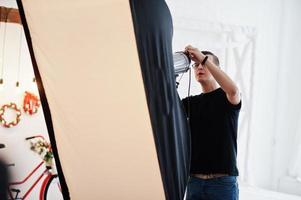 le photographe ajuste la lumière du flash sur le studio. photo