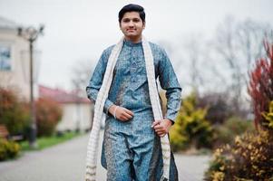 l'homme indien porte des vêtements traditionnels avec une écharpe blanche posée à l'extérieur. photo