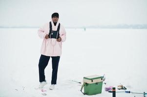 pêcheur afro-américain sur la mer gelée. pêche d'hiver. photo