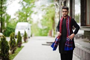 l'homme pakistano bangladesh porte des vêtements traditionnels noirs et des lunettes pose à l'extérieur. photo